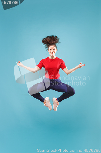 Image of Freedom in moving. Pretty young woman jumping against pink background