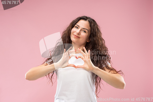 Image of The happy business woman standing and smiling against pink background.