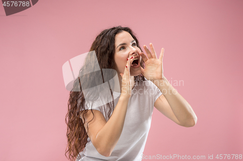 Image of Isolated on pink young casual woman shouting at studio