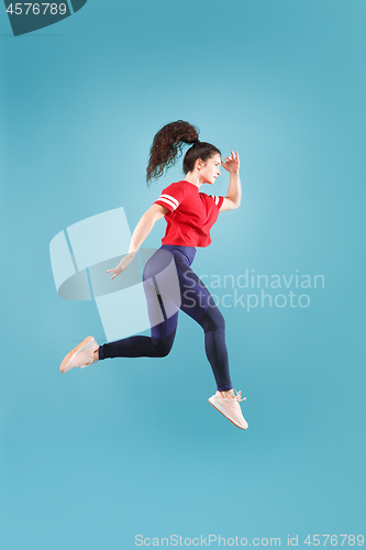 Image of Freedom in moving. Pretty young woman jumping against pink background