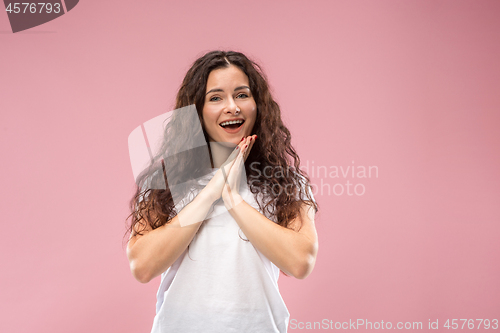 Image of The happy business woman standing and smiling against pink background.