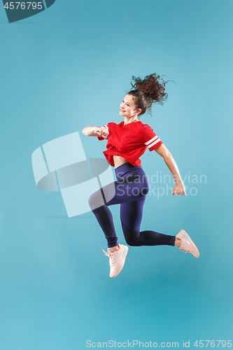 Image of Freedom in moving. Pretty young woman jumping against pink background