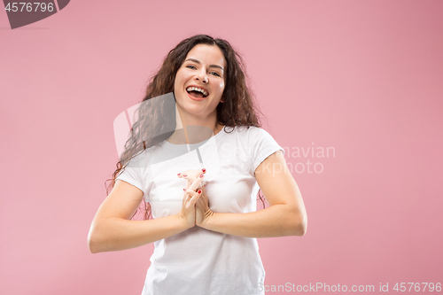 Image of The happy business woman standing and smiling against pink background.