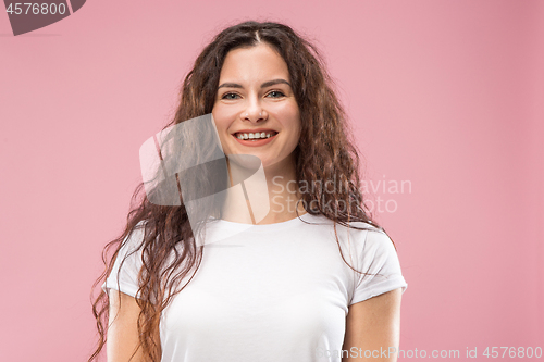 Image of The happy business woman standing and smiling against pink background.