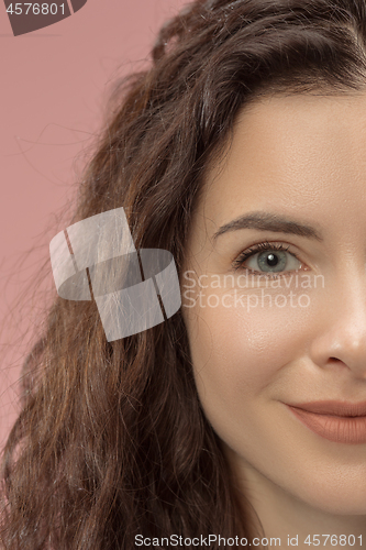 Image of The happy business woman standing and smiling against pink background.
