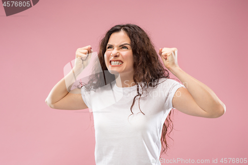 Image of Portrait of an angry woman isolated on a pink background