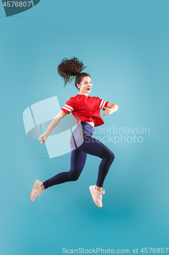 Image of Freedom in moving. Pretty young woman jumping against pink background