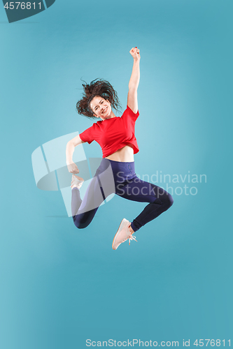 Image of Freedom in moving. Pretty young woman jumping against pink background