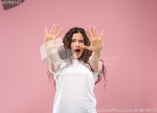 Image of Portrait of the scared woman on pink