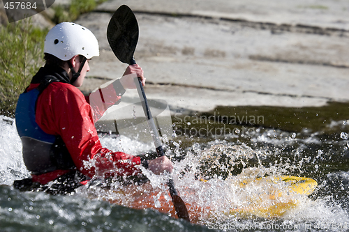 Image of whitewater kayaker surfing on a wave