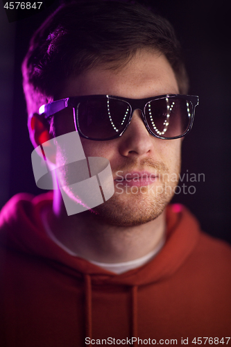 Image of man in sunglasses over ultra violet neon lights