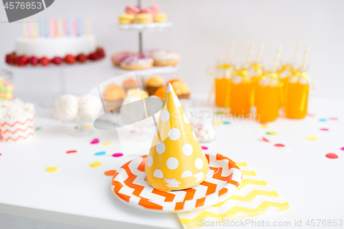 Image of party caps, food and drinks on birthday