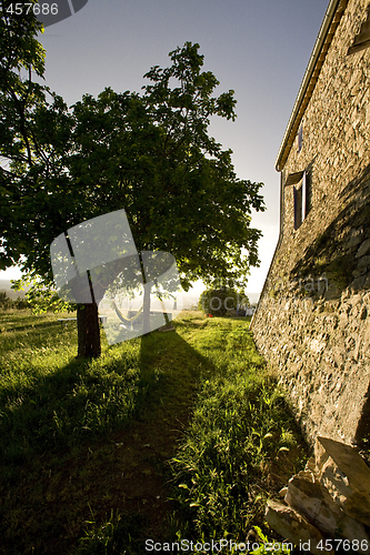 Image of hammock in trees and old stone farmhouse france