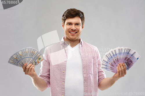 Image of happy young man with fans of euro and dollar money