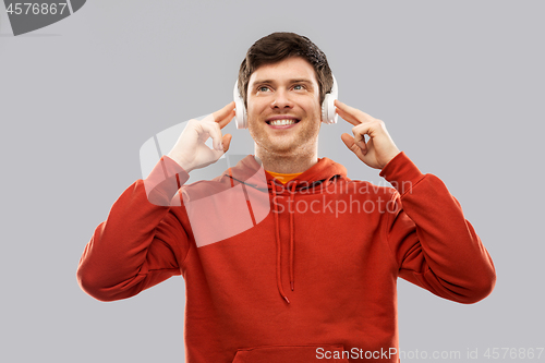 Image of happy young man in headphones and red hoodie