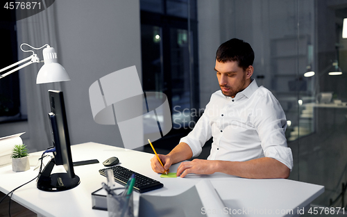 Image of businessman with computer working at night office