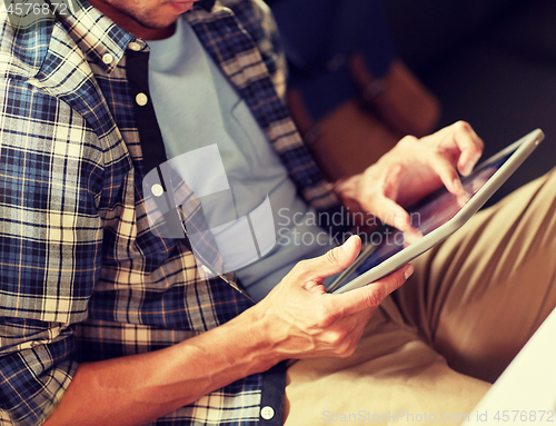 Image of close up of man with tablet pc sitting at cafe