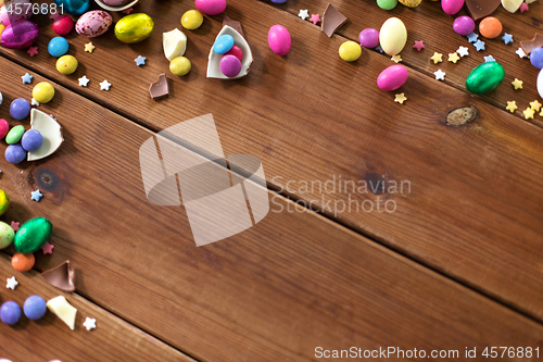 Image of chocolate eggs and candy drops on wooden table