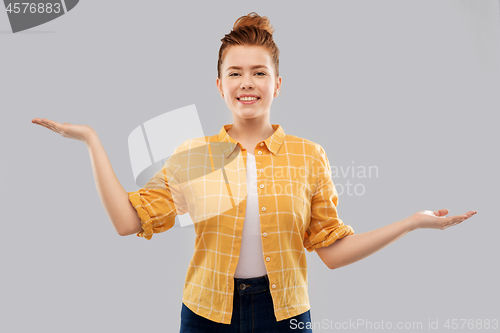 Image of happy red haired teenage girl holding empty hands