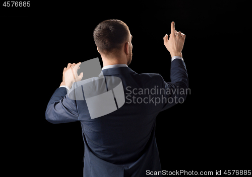 Image of businessman working with invisible virtual screen