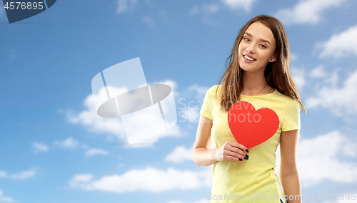 Image of smiling teenage girl with red heart over sky