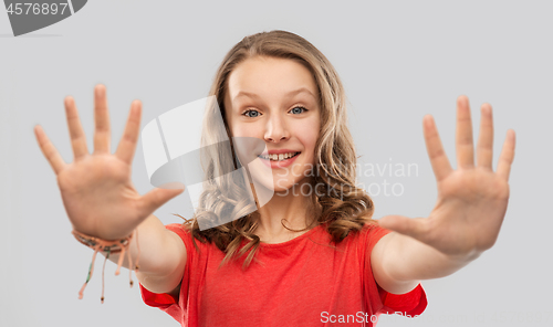 Image of happy teenage girl in red t-shirt giving high five
