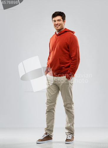 Image of young man in red hoodie over grey background