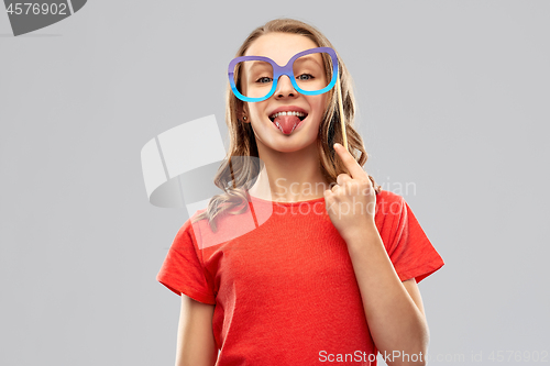 Image of teenage girl with party prop showing tongue