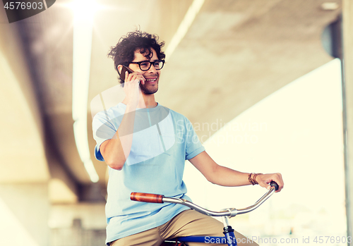 Image of man with smartphone and fixed gear bike on street