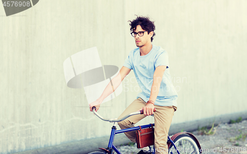 Image of young hipster man riding fixed gear bike