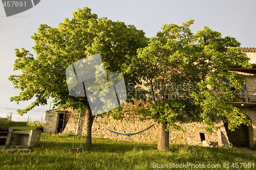 Image of hammock in trees and old stone farmhouse france