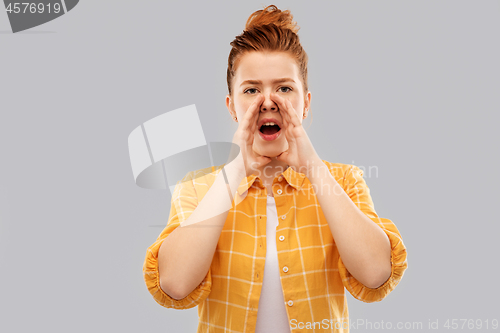 Image of red haired teenage girl calling someone