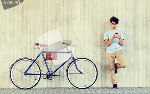 Image of man with smartphone and fixed gear bike on street