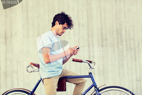 Image of man with smartphone and fixed gear bike on street