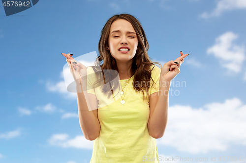 Image of young woman or teenage girl with fingers crossed