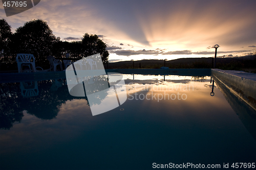 Image of reflection of sunset over swimming pool