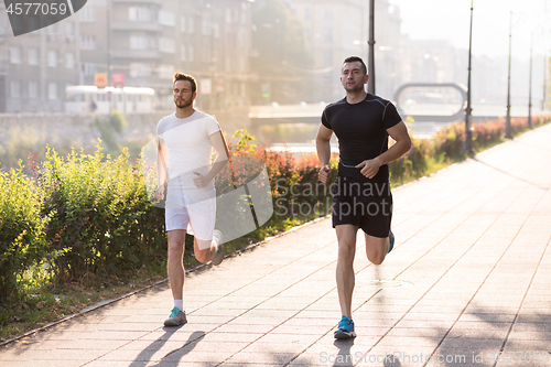 Image of group of young people jogging in the city