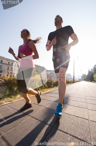 Image of young couple jogging  in the city