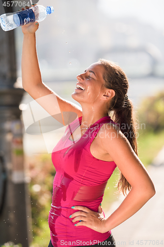 Image of woman pouring water from bottle on her head