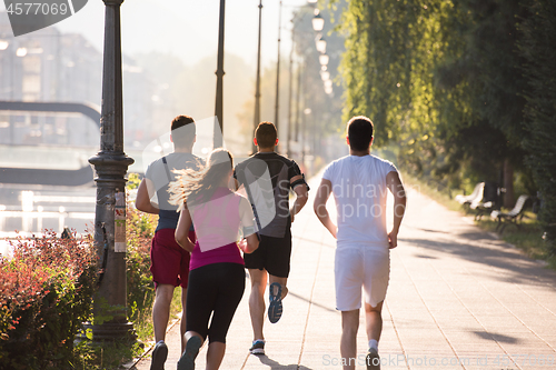 Image of group of young people jogging in the city