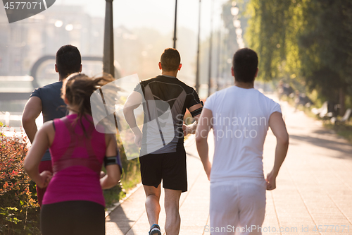 Image of group of young people jogging in the city