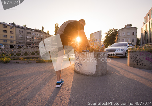 Image of man tying running shoes laces