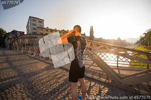 Image of portrait of a jogging man at sunny morning