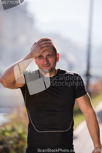 Image of man pouring water from bottle on his head