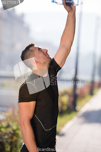 Image of man pouring water from bottle on his head