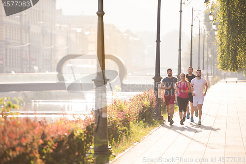 Image of group of young people jogging in the city