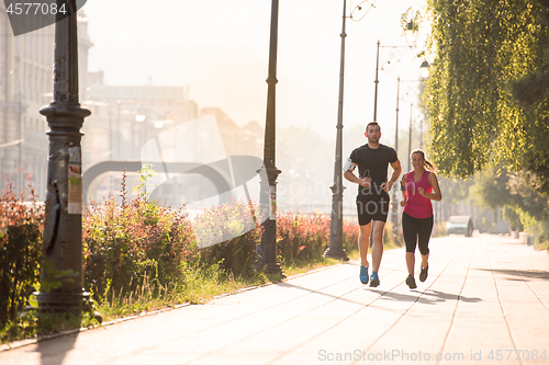 Image of young couple jogging  in the city