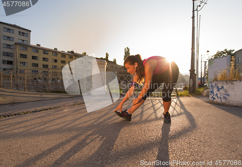 Image of athlete woman warming up and stretching