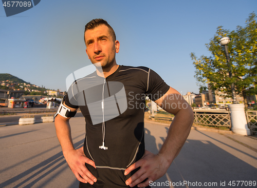 Image of portrait of a jogging man at sunny morning