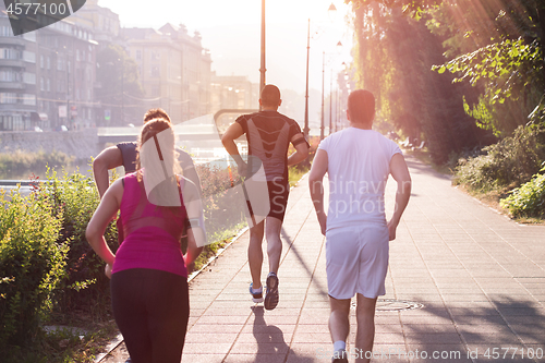 Image of group of young people jogging in the city